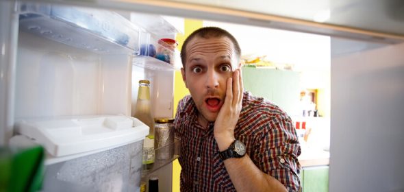man looking in fridge eyes wide open
