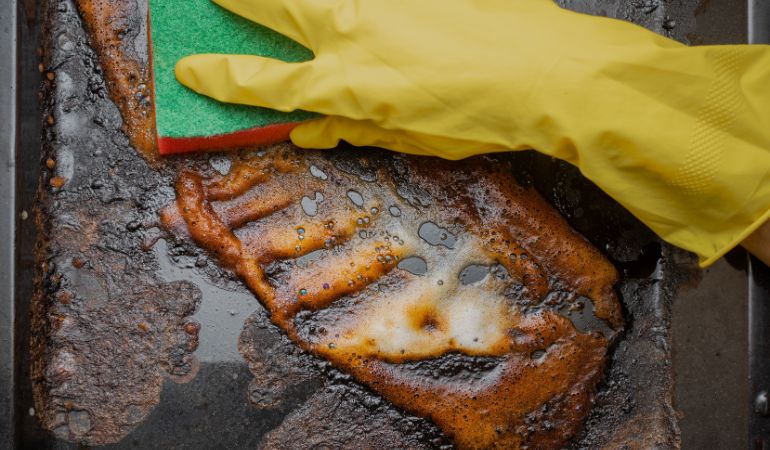 Cleaning enamel oven tray with a sponge