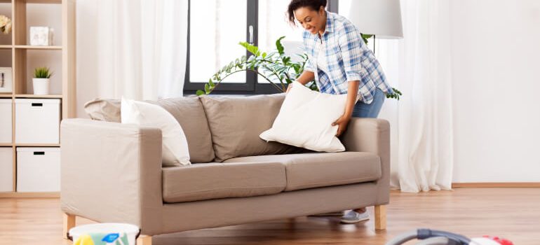 Woman cleaning sofa cushions