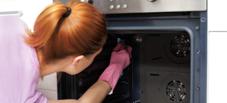 Woman cleaning inside oven