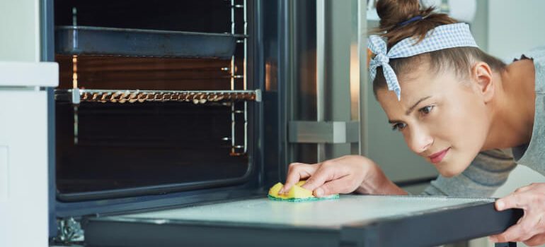 Woman cleaning an oven door