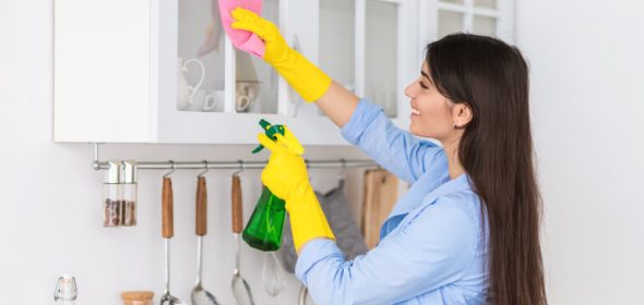 Woman cleaning kitchen cabinets