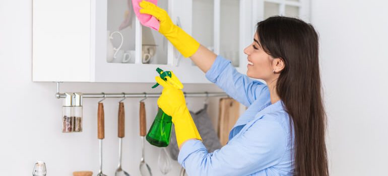 Woman cleaning kitchen cabinets