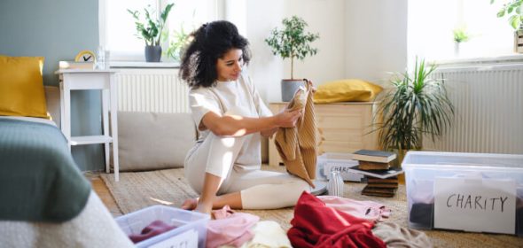 Young woman decluttering her bedroom