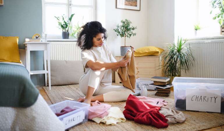 Young woman decluttering her bedroom